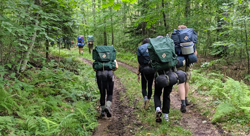 National Youth Science Camp participants hiking in the woods